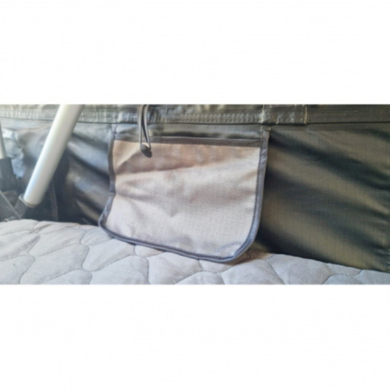 Vue intérieure de la tente de toit montrant le matelas en mousse haute densité et les rangements.