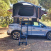 Vue panoramique de la tente de toit Eclipse de Soplair ouverte sur un suv en forêt