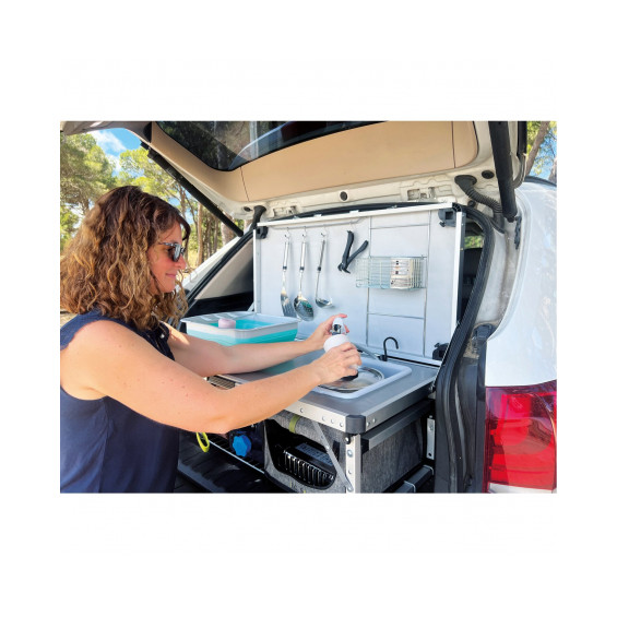 Femme utilisant la bassine intégrée du Kitch&Box Incasa dans le coffre d'un SUV blanc