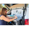 Femme utilisant la bassine intégrée du Kitch&Box Incasa dans le coffre d'un SUV blanc
