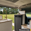 Réfrigérateur 90l noir Nomadic Ark installé dans un van avec vue sur l'extérieur