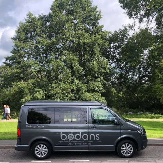 Volkswagen Transporter T5 gris équipé d'une fenêtre coulissante avant droite, vue de profil