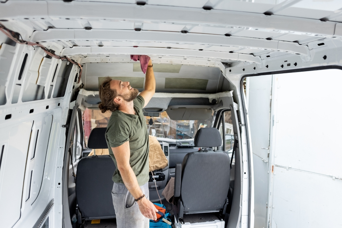 Homme nettoyant le toit intérieur d'un van